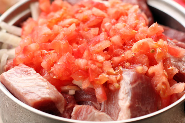 Репчатый лук порежьте полукольцами, добавьте в него морской соли и пожмите руками, чтобы он дал сок. Добавьте к мясу лук и помидоры.