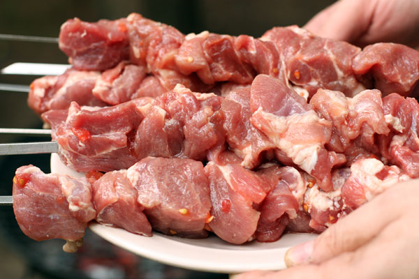 Замаринованную свинину равномерно нанизывайте на шампуры.