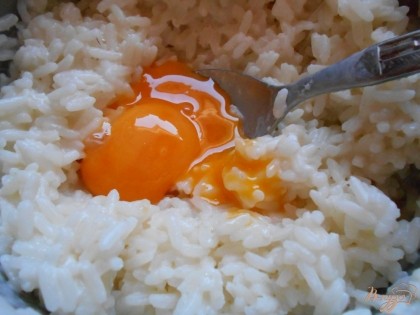 Яйца разделяем на белки и желтки. Желтки добавляем к рису и хорошо все перемешиваем.