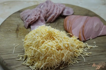 Ветчину и салями нарезать полукольцами, сыр натереть на мелкую терку.