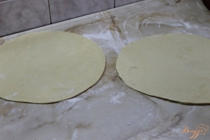 Тонко раскатать тесто и вырезать заготовку с помощью круглой доски.