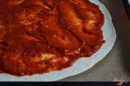 Тесто раскатать тонко, поверхность смазать томатным соусом.