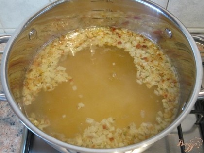 В бульон добавить лук с чесноком, тимьян и варить 10 минут.