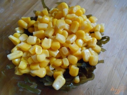 В салатник выкладываем морскую капусту и кукурузу консервированную.