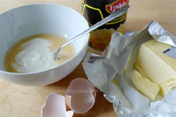 В другой миске смешать слегка взбитое яйцо, сметану, растопленное масло, ром и ананасовый сок. Тщательно все перемешать.    