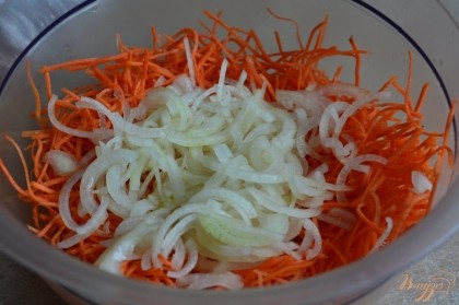 В миску настрогать морковь, добавить маринованный лук. Раскалить масло и вылить на овощи.