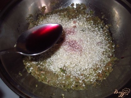 Затем, добавьте рис, воду и вино. Жарьте на медленном огне, постоянно помешивая. Ризотто должно получится вязким, а не рассыпчатым, поэтому нужно брать рис клейких сортов.
