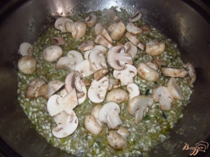 Нарежьте тонко шампиньоны, добавьте к рису. Влейте мясной бульон. Жарьте до готовности риса и грибов, минут 15.