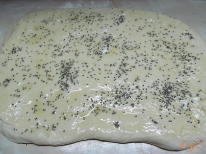 После увеличения тесто вынуть и на рабочей поверхности присыпанной мукой, придать форму прямоугольника. Смазать оливковым маслом и посыпать семенами чиа.
