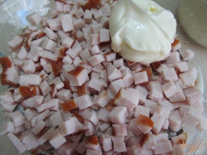Копченое мясо нарезать мелким кубиком и выложить на салат. Смазать майонезом.