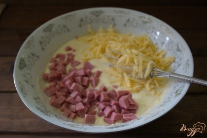 Нарежьте ветчину, а сыр натрите на терке. Добавьте продукты в тесто и снова перемешайте.