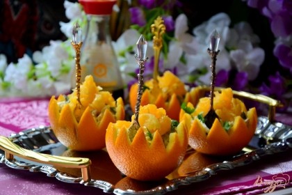 Салат выложить в подготовленные апельсиновые корзиночки. Сверху украсить мякотью апельсина