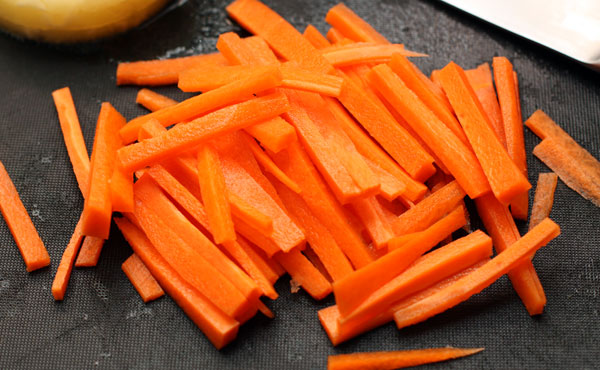 Морковь нарежьте соломкой. Также нарежьте соломкой зеленый и красный перец.