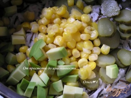 Добавить нарезанное кусочками авокадо, огурцы и кукурузу, перемешать.
