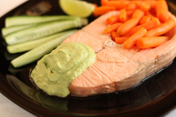 С готовой рыбы снимите шкуру. Рыбу положите на тарелки. Бульон можете сохранить и использовать как основу для других блюд или соусов.  Полейте рыбу соусом, а на гарнир подайте какие-нибудь овощи, потому что блюдо очень сытное само по себе. 