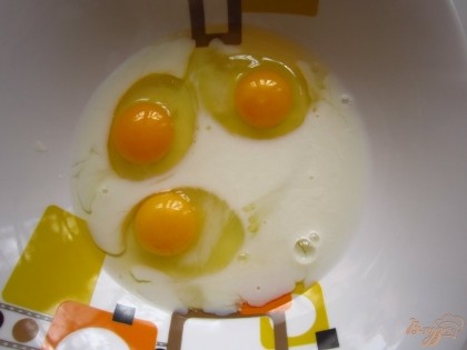 В миску влейте молоко, выбейте яйца и взбейте венчиком.