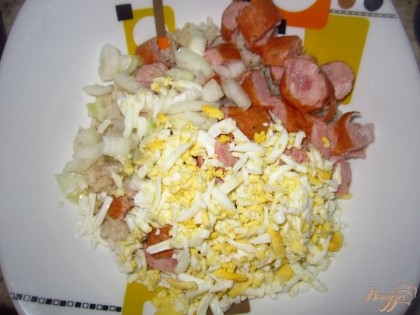 В миску положите: сосиски, рис, яйца. Слейте маринад с лука и добавьте его в салат.Посолите и перемешайте.