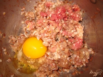 Пока лук обжаривается. В миску положите гречку, свиной фарш, соль, щепотку черного перца, яйцо, перемешайте.