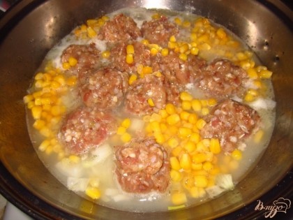 Залейте соусом тефтели и добавьте кукурузу. Варите на медленном огне, под закрытой крышкой минут 10.