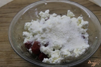 Соединить ягоды с творогом и сахаром. Перебить до однородной массы с помощью блендера.