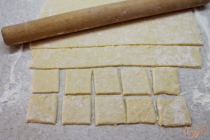 Творожное тесто раскатываем толщиной 2-3 мм и разрезаем на квадраты.