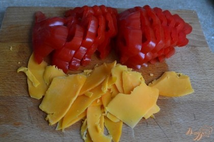 Большой помидор нарезать на дольки.Сыр нарезать тонкими ломтиками.