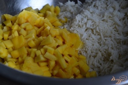 В миску выложить отварной рис и кусочки манго.