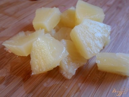 Консервированный ананас просушиваем от сока и нарезаем небольшими кусочками.
