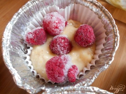 В формочку выкладываем немного теста, потом сверху выкладываем ягоды малины, у меня- замороженная малина.