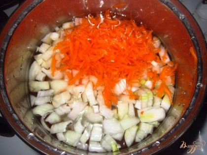 Вскипятите воду. Лук и морковь очистить от кожуры. Мелко нарежьте лук, а морковь натрите на большой терке. Положите овощи в кипящую воду, посолите.