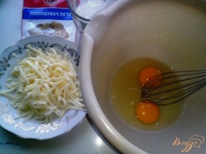 Натереть твёрдый сыр на тёрке (понадобится для присыпки нашего пирога). Разбить яйца в миску для последующего взбивания.