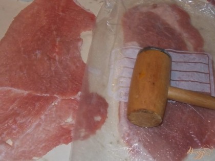 Прежде всего нам нужно хорошо отбить мясо. Для этого я использую кухонный молоток и пластиковый пакет, чтобы не повредить целостность филе. Мясо солим и перчим с обеих сторон.