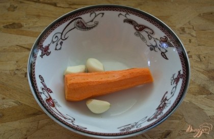 Морковь и чеснок нарезать на небольшие кусочки. Нашпигуйте мясо подготовленными овощами.