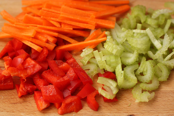 Перец нарежьте кубиками, сельдерей тонкими ломтиками, а морковь соломкой.