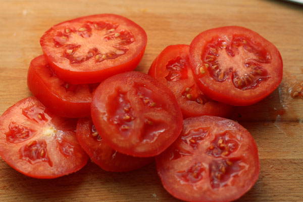 Нарежьте помидоры кружочками, а перец длинными "лодочками".