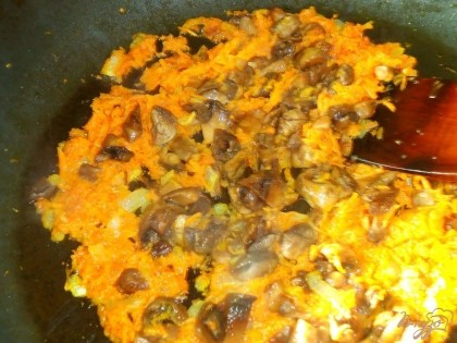 Лук обжариваем на оливковом масле в глубокой сковороде, затем добавляем грибы и морковь, тушим около 5 минут. 4