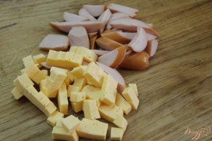 Сыр твердый нарезать кубиком, сосиски наискось колечками.