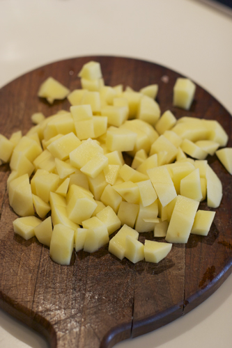 Пока мясо варится чистим и нарезаем кубиками картофель. Бросаем в кастрюлю.