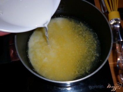 Oставшуюся воду влить в кастрюлю, добавить сок и цедру 2 лимона, поставить на огонь. Влить крахмал. Помешивая, довести до кипения и варить 2 минуты.