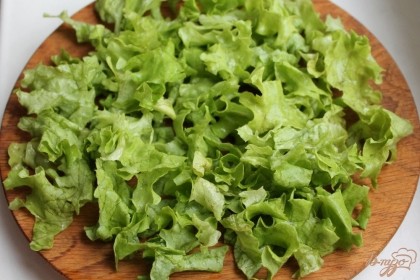 Листья салата промываем, сушим и разрываем на кусочки. Салат выкладываем на плоскую тарелку.