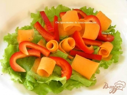 Морковь нарезать с помощью овощечистки, завернуть в колечки и выложить сверху. Добавить перец, нарезанный брусочками.