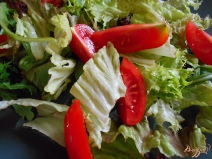 На блюдо выкладываем листья салата, у меня - итальянская смесь. Помидоры черри разрезаем на половинки, те, что покрупнее- на четвертинки и выкладываем к салату.