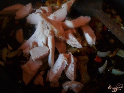 Поскольку мы готовим плов на скорую руку, то куриное филе берем отварное. Нарезаем его сначала пластинами, а затем небольшими кусочками. Отправляем мясо к луку и специям и даем ему пропитаться специями.