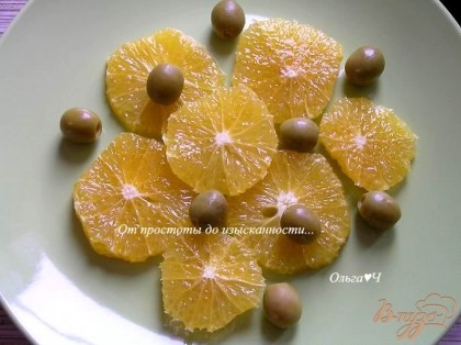 Апельсины филировать (выделившийся сок собрать для заправки), нарезать кружочками, разложить по тарелкам, добавить оливки.