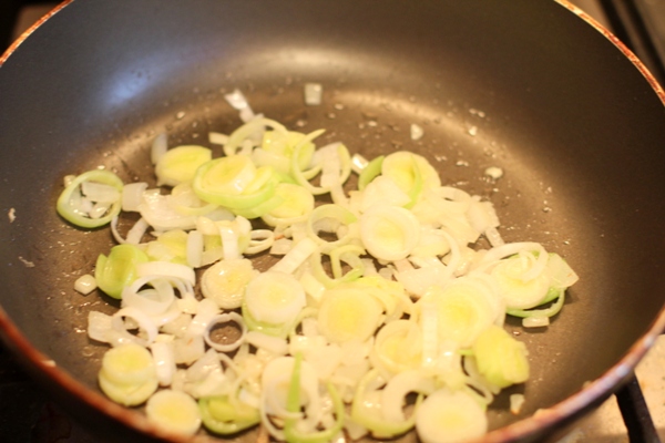 Лук порей порезать колечками, репчатый лук мелко нашинковать. На несильно разогретой сковороде потушить овощи с небольшим количеством растительного масла и воды.