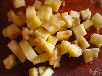 С ананаса слейте воду и нарежьте его на мелкие кусочки.