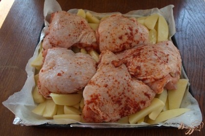Куриные бедра уложите поверх картошки. Разогрейте духовку  до 200 градусов. Запекайте все вместе 1 час.