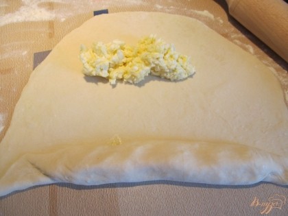 Для хачапури по-аджарски раскатываем тесто толщиной 2-3 мм. Выкладываем две полоски из начинки.
