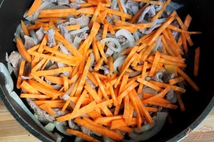 Далее, на очереди морковь, ее нарезаем соломкой и добавляем в сковородку.