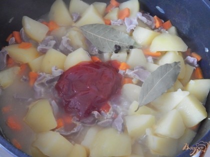 Когда овощи почти готовы, добавляем томатную пасту, варёные желудочки, лавровый лист, соль и перец и тушим ещё минут 10.